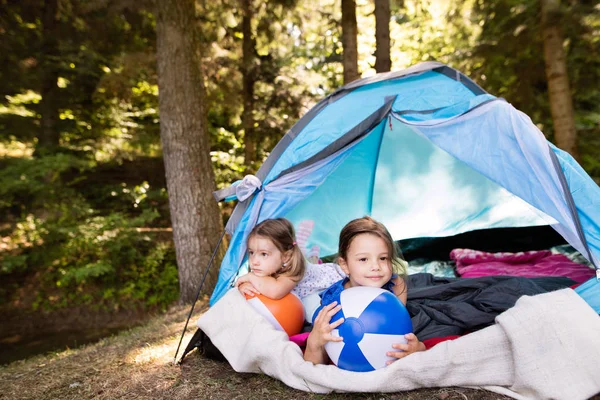 Piękne małe dziewczynki w camping namiot w lesie. — Zdjęcie stockowe
