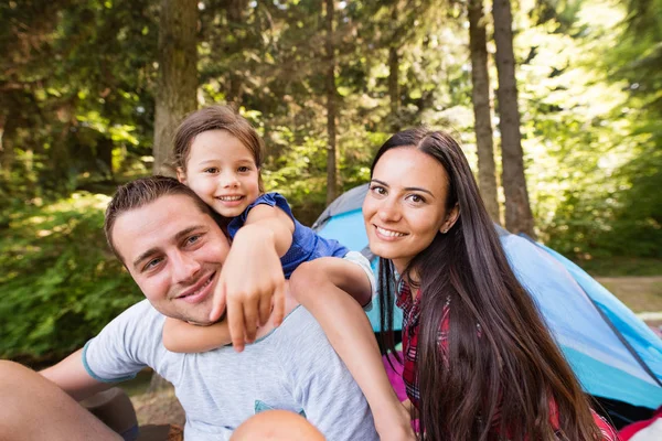 Schöne junge Familie mit Tochter campiert im Wald. — Stockfoto