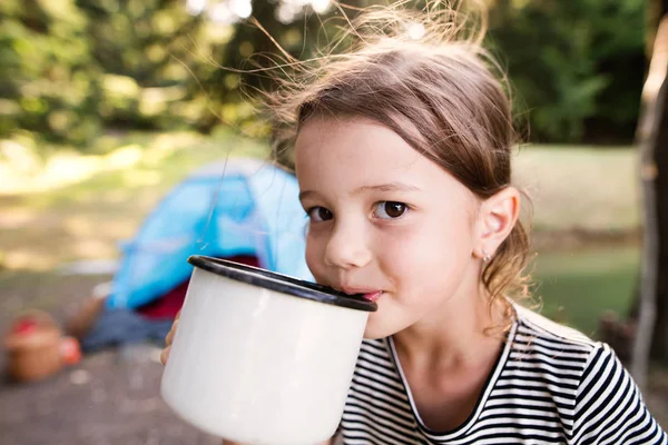 Ładna dziewczynka camping na zewnątrz, wody pitnej. — Zdjęcie stockowe