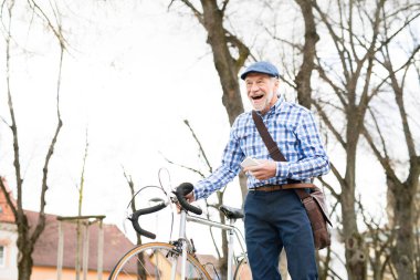 Üst düzey adam akıllı telefon ve şehirde bisiklet.