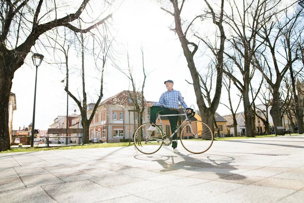 Hombre mayor en camisa de cuadros azules con bicicleta en la ciudad . — Foto de Stock