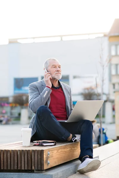 Senior man in de stad met de slimme telefoon, telefoongesprek maken — Stockfoto