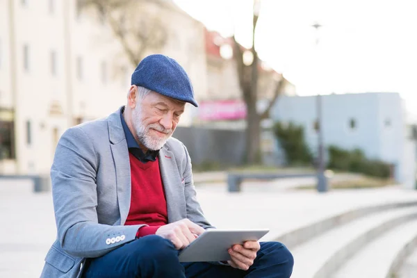 Uomo anziano in città con tablet, fare telefonate — Foto Stock