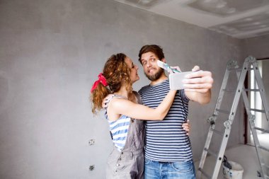 Çift evde boyama duvarları selfie smartphone ile alarak,.