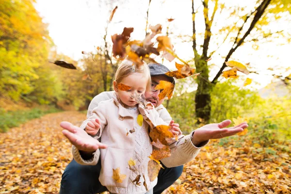 Junger Vater mit Tochter im Herbstwald. — Stockfoto