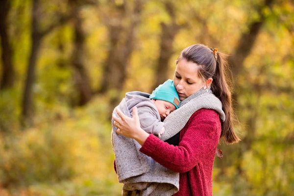 秋の森歩きの赤ちゃんの息子を持つ若い母親. — ストック写真