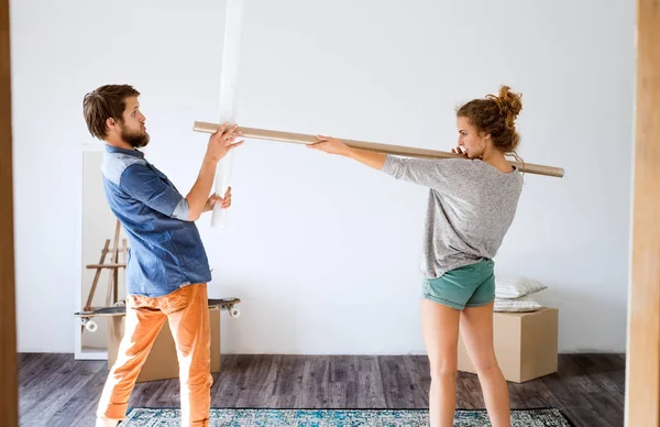 Unga par som flyttar i nya huset kämpar. — Stockfoto