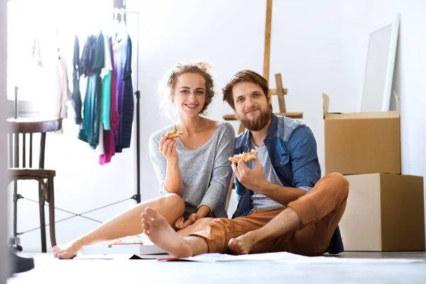 Ungt par sitter på golvet rör sig i nya huset. — Stockfoto