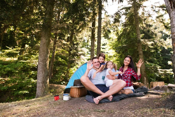 Beautiful young family with daughters camping in forest. — Stock Photo, Image