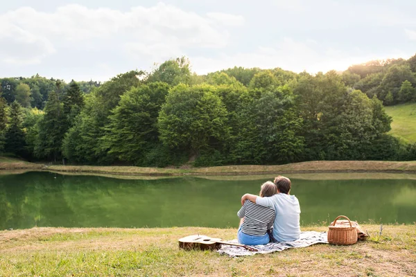 Senior couple at the lake having a picnic — Stock Photo, Image