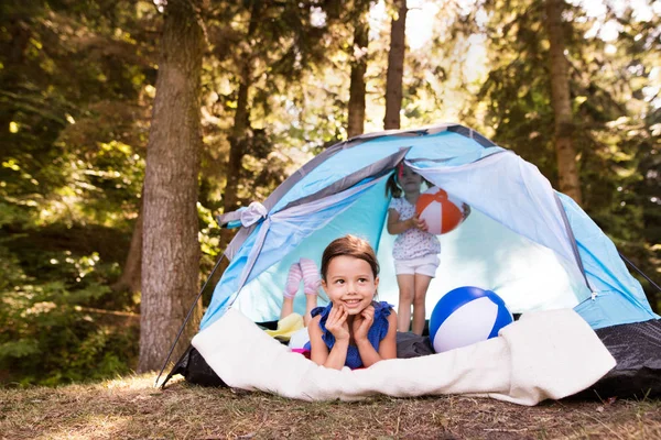 Beautiful little girls in tent camping by the lake. — Stock Photo, Image