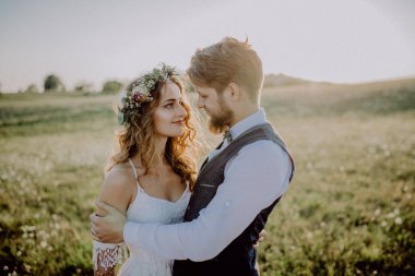 Güzel gelin ve damat yeşil doğa gün batımında.