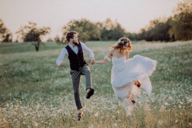 Güzel gelin ve damat yeşil doğa gün batımında.
