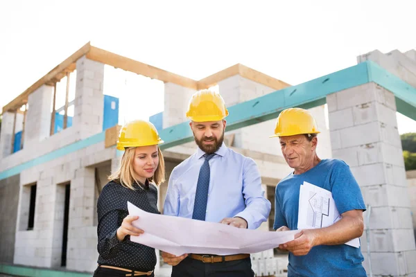 Arquitetos e trabalhadores no canteiro de obras . — Fotografia de Stock