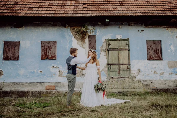 Hermosa novia y novio en frente de la vieja casa en mal estado . —  Fotos de Stock