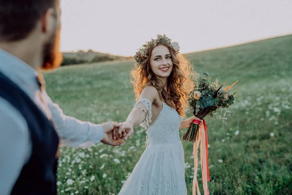 Gyönyörű menyasszony és a vőlegény, napnyugtakor a zöld természet. — Stock Fotó
