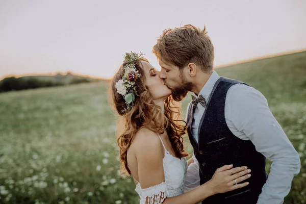 Vackra bruden och brudgummen vid solnedgången i gröna naturen. — Stockfoto