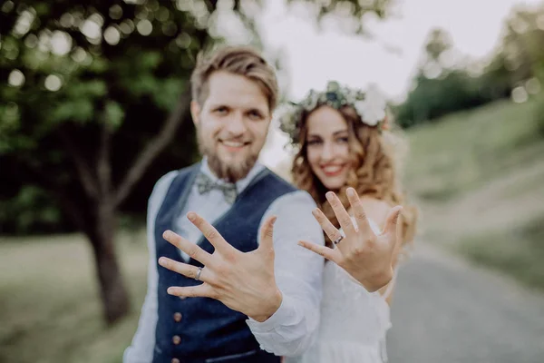 Noiva e noivo com anéis de casamento na natureza . — Fotografia de Stock