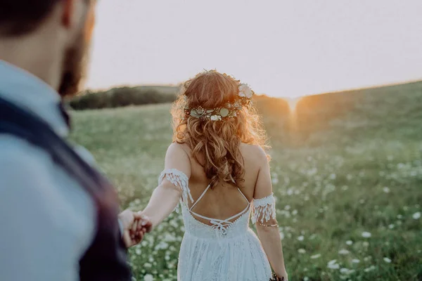 Vackra bruden och brudgummen vid solnedgången i gröna naturen. — Stockfoto