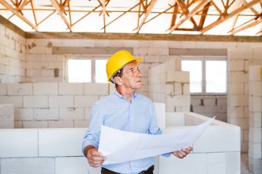 Üst düzey mimar veya inşaat mühendisi inşaat sahasında.