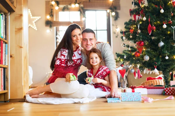 Mladá rodina s dcerkou na vánoční stromeček doma. — Stock fotografie
