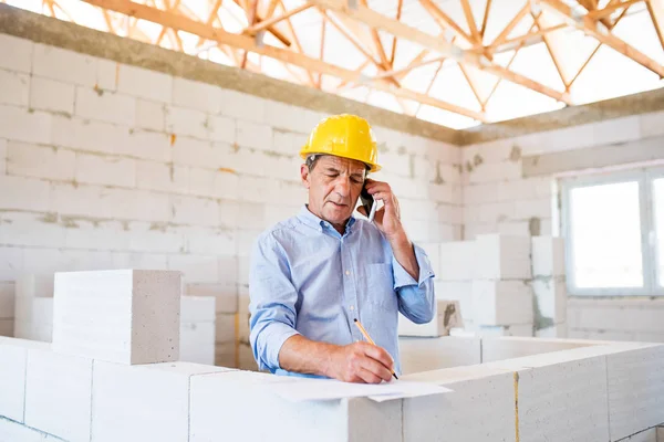 Chefarchitekt mit Smartphone auf der Baustelle. — Stockfoto