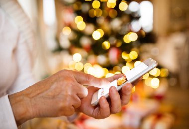 Smartphone Noel ağacı önünde tanınmayan kadınla.