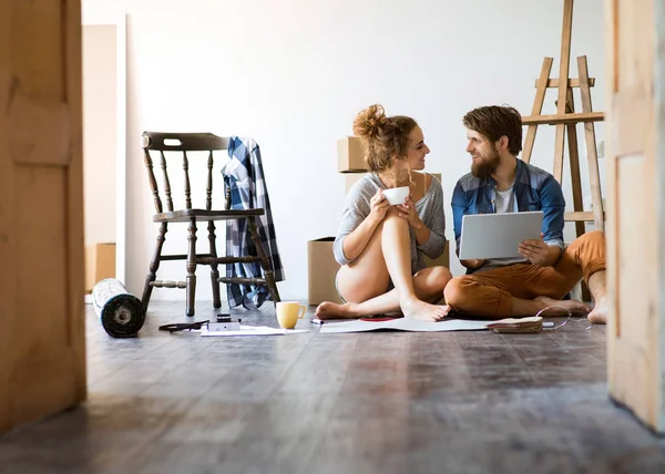 Casal jovem se movendo na nova casa, desempacotando coisas . — Fotografia de Stock