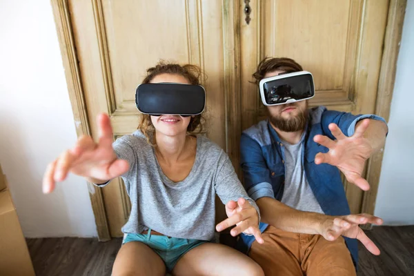 Young couple with VR glasses moving in new house. — Stock Photo, Image