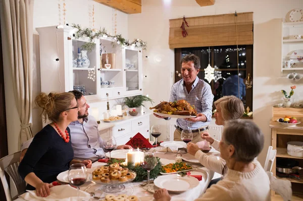 Család ünnepli karácsony. Apa hozza a ételek. — Stock Fotó
