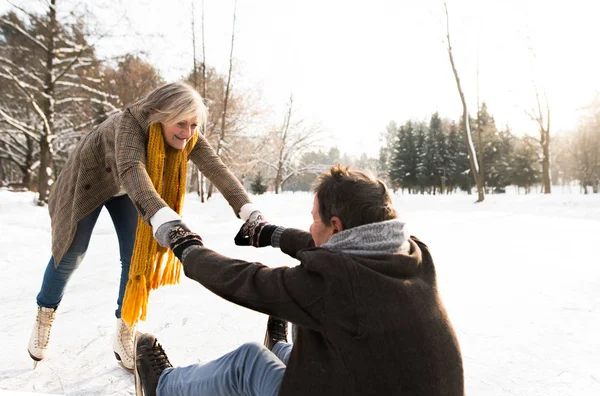 Seniorenpaar in sonniger Winternatur beim Eislaufen. — Stockfoto