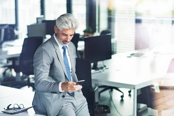 Mogen affärsman med smartphone på kontoret. — Stockfoto