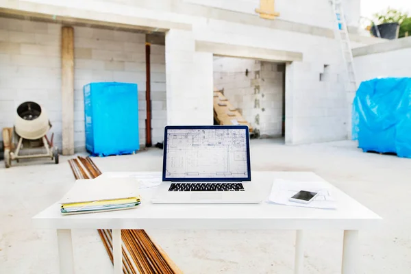 Plantas e laptop no canteiro de obras . — Fotografia de Stock