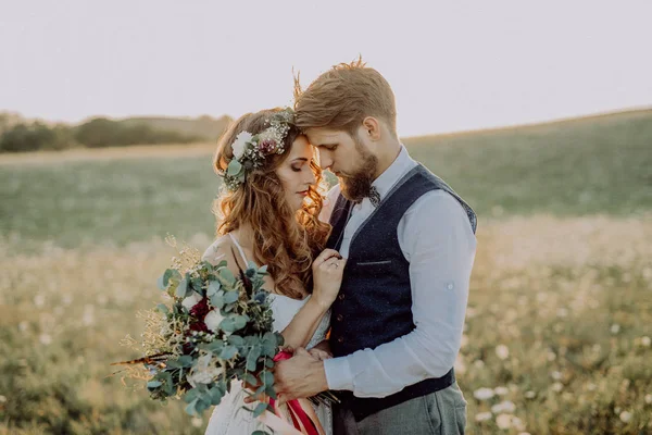 Bela noiva e noivo ao pôr do sol na natureza verde . — Fotografia de Stock