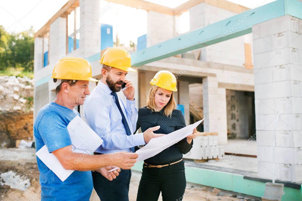 Architects and worker at the construction site.