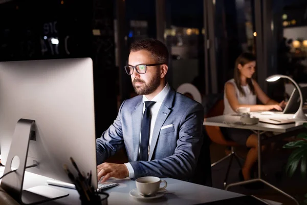 Zakenman in zijn kantoor in de nacht werkt laat. — Stockfoto