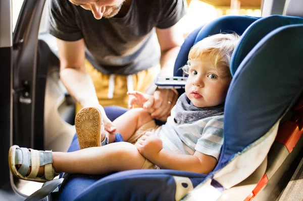 Otec fixační pás pro svého syna sedí v autě. — Stock fotografie