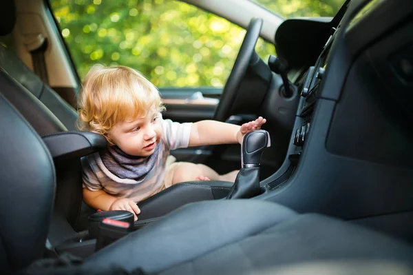 Маленький хлопчик грає в машині, роблячи вигляд, що керує нею . — стокове фото