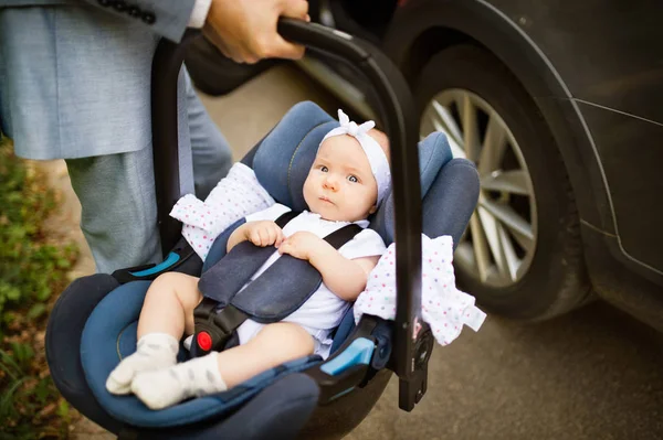 Homme méconnaissable portant sa petite fille dans un siège d'auto . — Photo