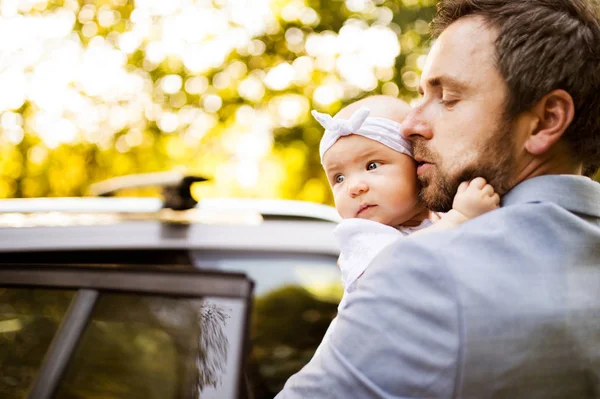 車に入る彼小さな女の赤ちゃんを持つ若い父. — ストック写真