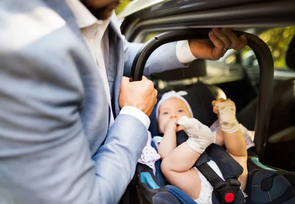 Hombre irreconocible poniendo niña en el coche . — Foto de Stock