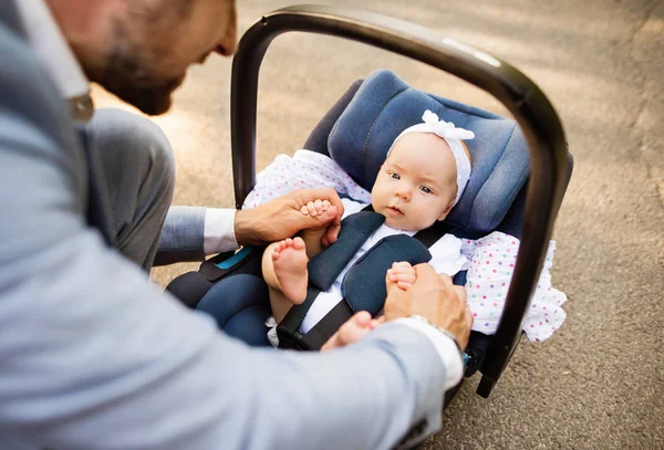 Vader met baby dochter zit in de zetel van de veiligheid van de auto. — Stockfoto