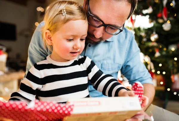 Liten flicka med hennes far öppnar julklapp. — Stockfoto