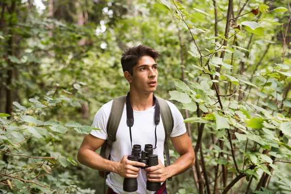 Dospívající chlapec s dalekohledem pěší v lese. Letní dovolená. — Stock fotografie