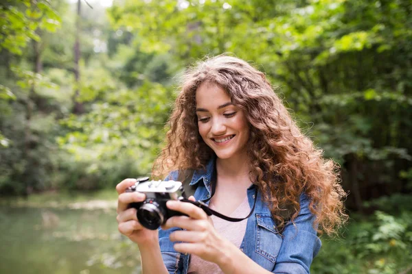 Ragazza adolescente escursioni nella foresta, scattare foto con macchina fotografica . — Foto Stock