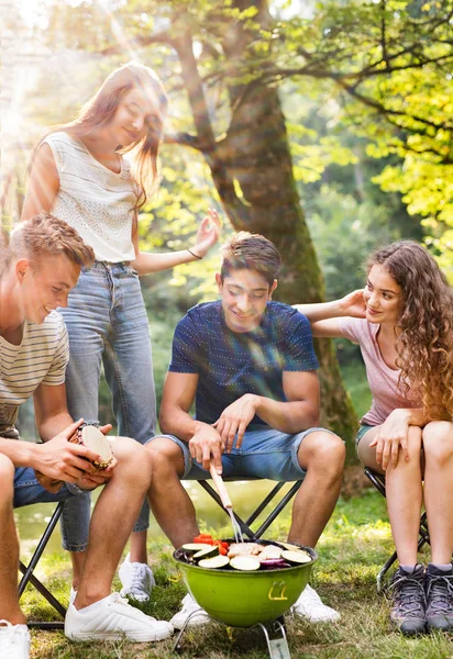 Tonåringar camping, Matlagning grönsaker på grillen. — Stockfoto