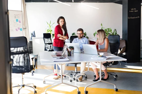 Three business people in the office talking together. — Stock Photo, Image