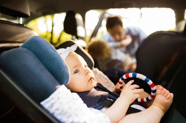 Liten flicka fast med säkerhet bälte i bil bilbarnstol. — Stockfoto