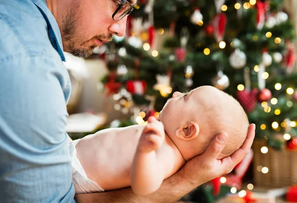 Unrecognizable father with baby boy in front of Christmas tree. — Stock Photo, Image