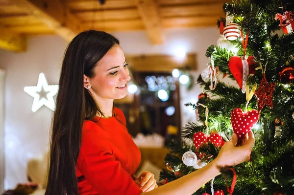 Jeune femme devant l'arbre de Noël le décorer — Photo